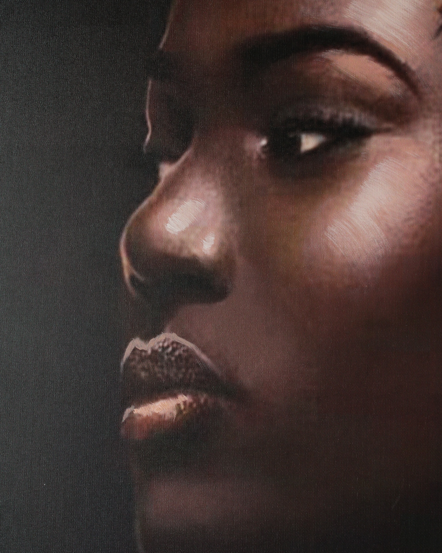 Close-up do rosto de uma mulher negra com fundo escuro