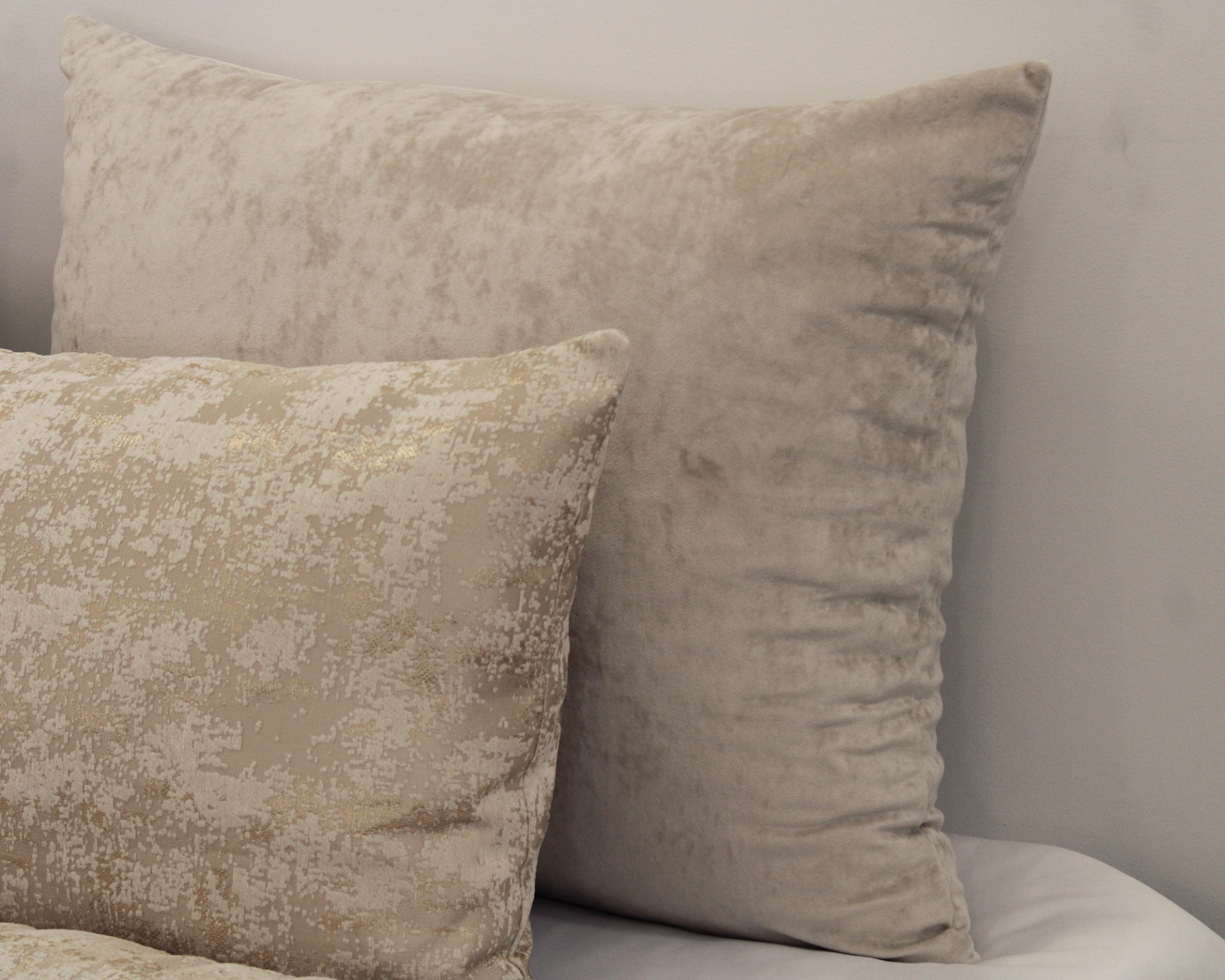 Duas almofadas decorativas em cama branca