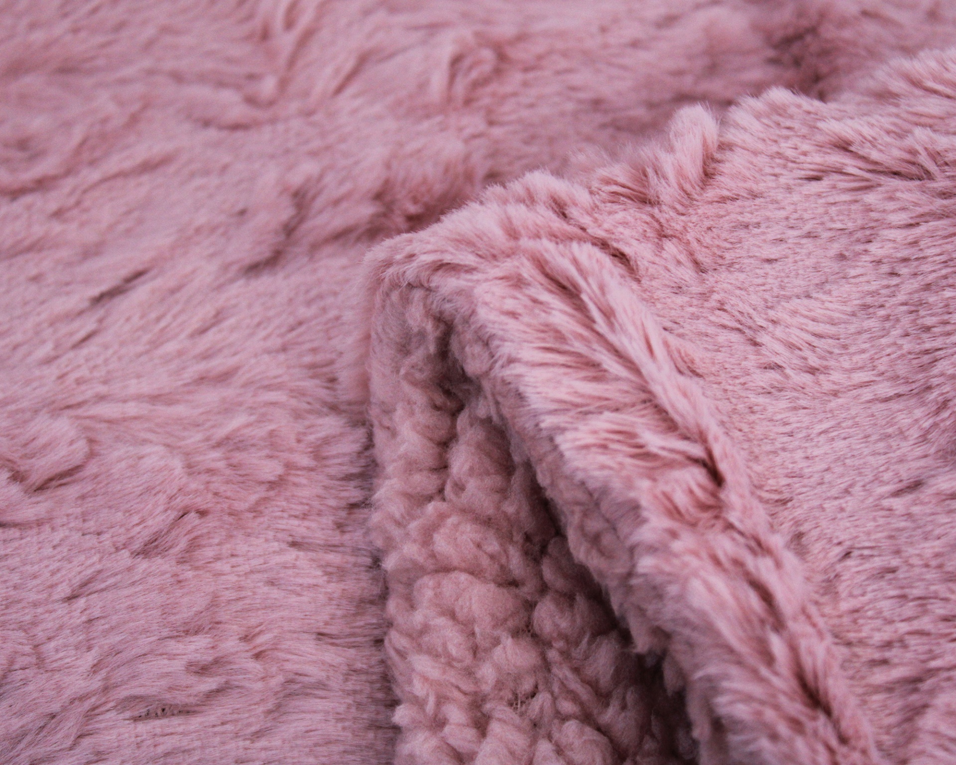 Tecido felpudo cor de rosa com textura macia dobrado.