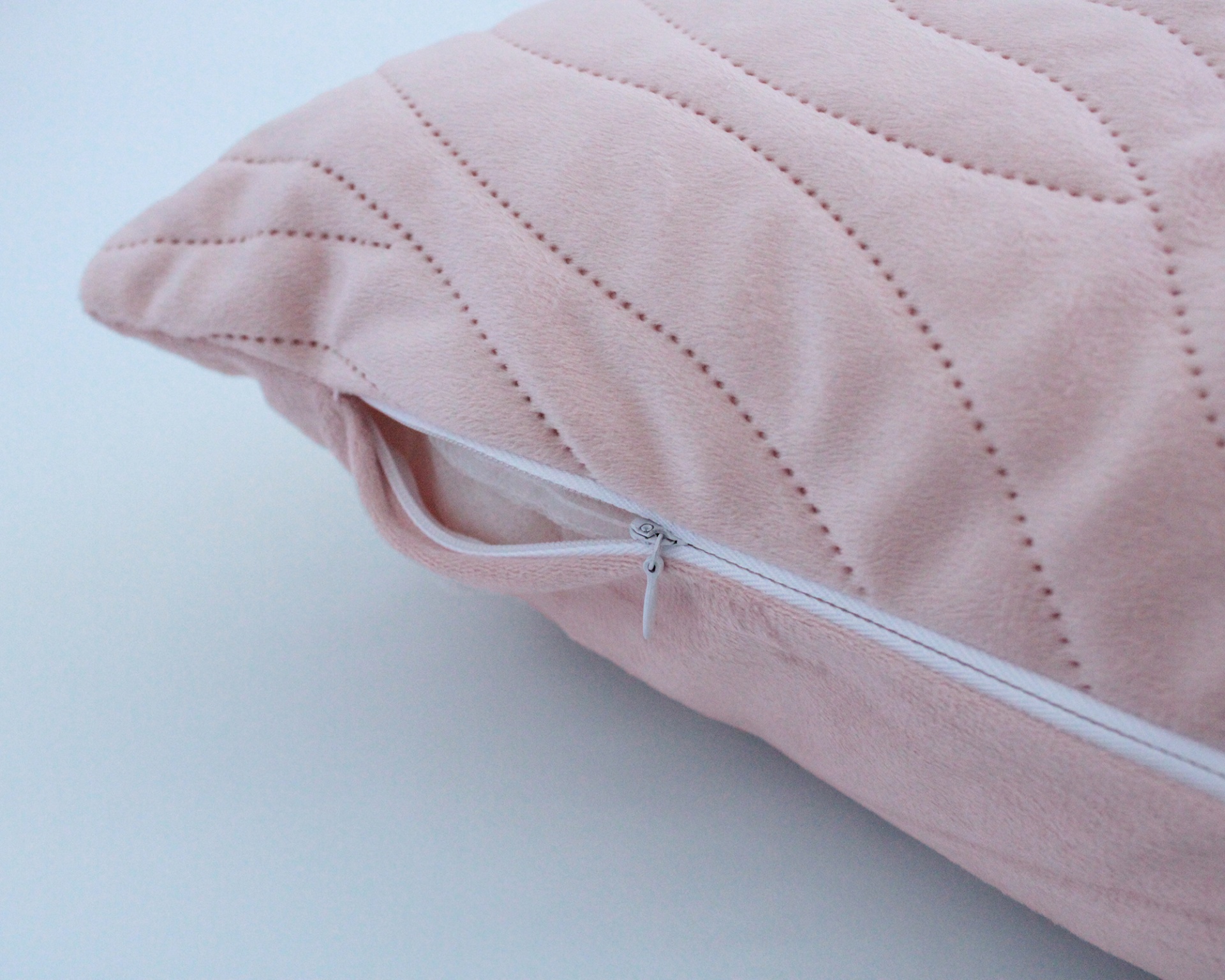 Almofada rosa com padrão ondulado e fecho de correr