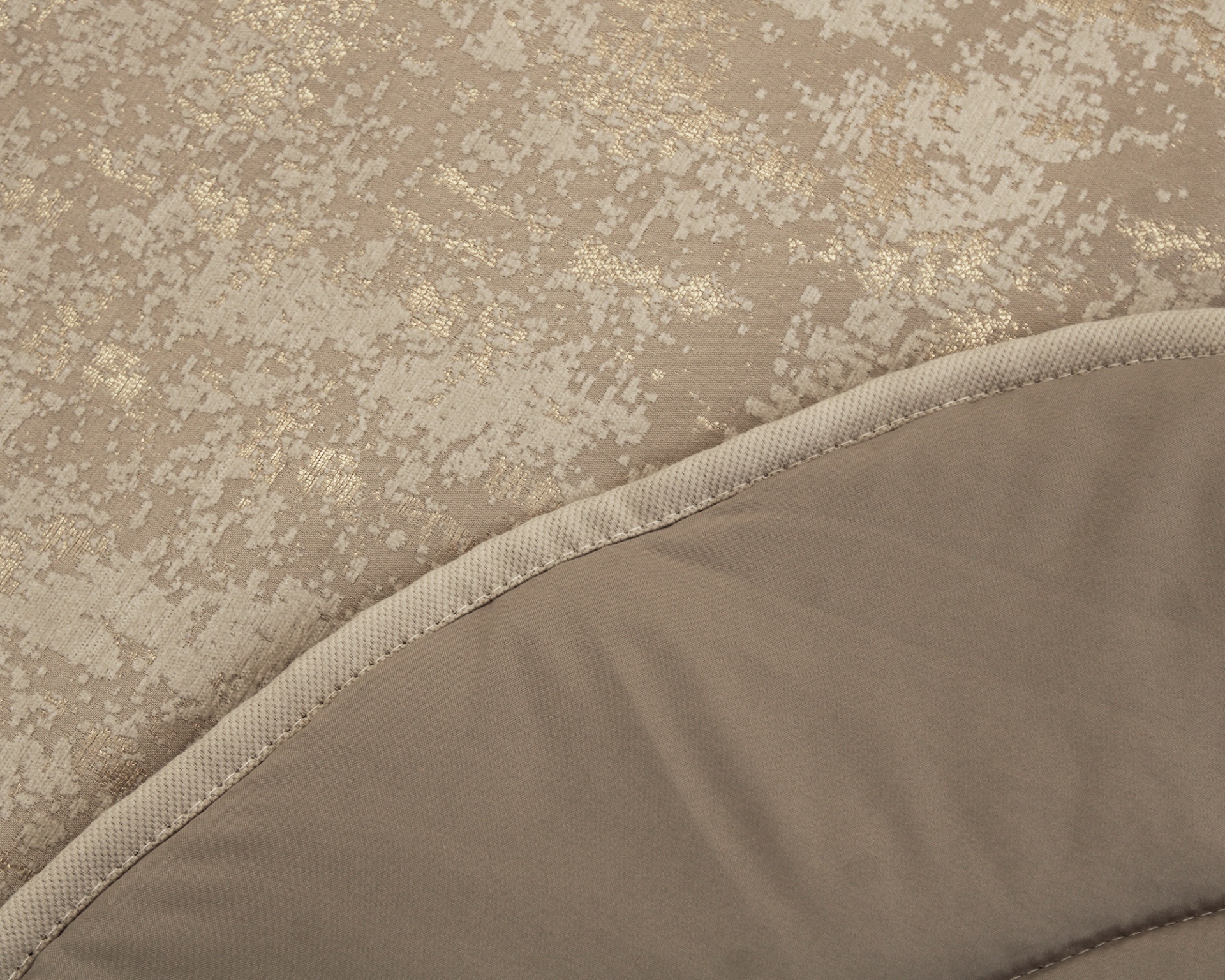Tecido bege com padrão dourado brilhante e tecido bege liso com costura