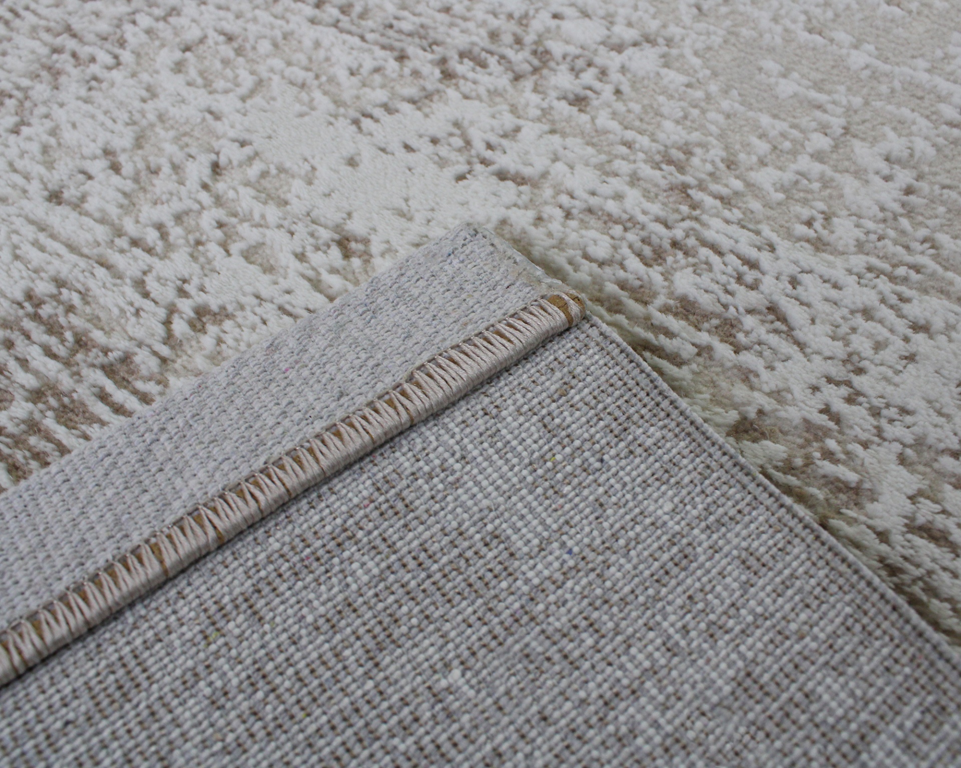 Tapete cinza claro tecido sobre tapete bege com padrão abstrato