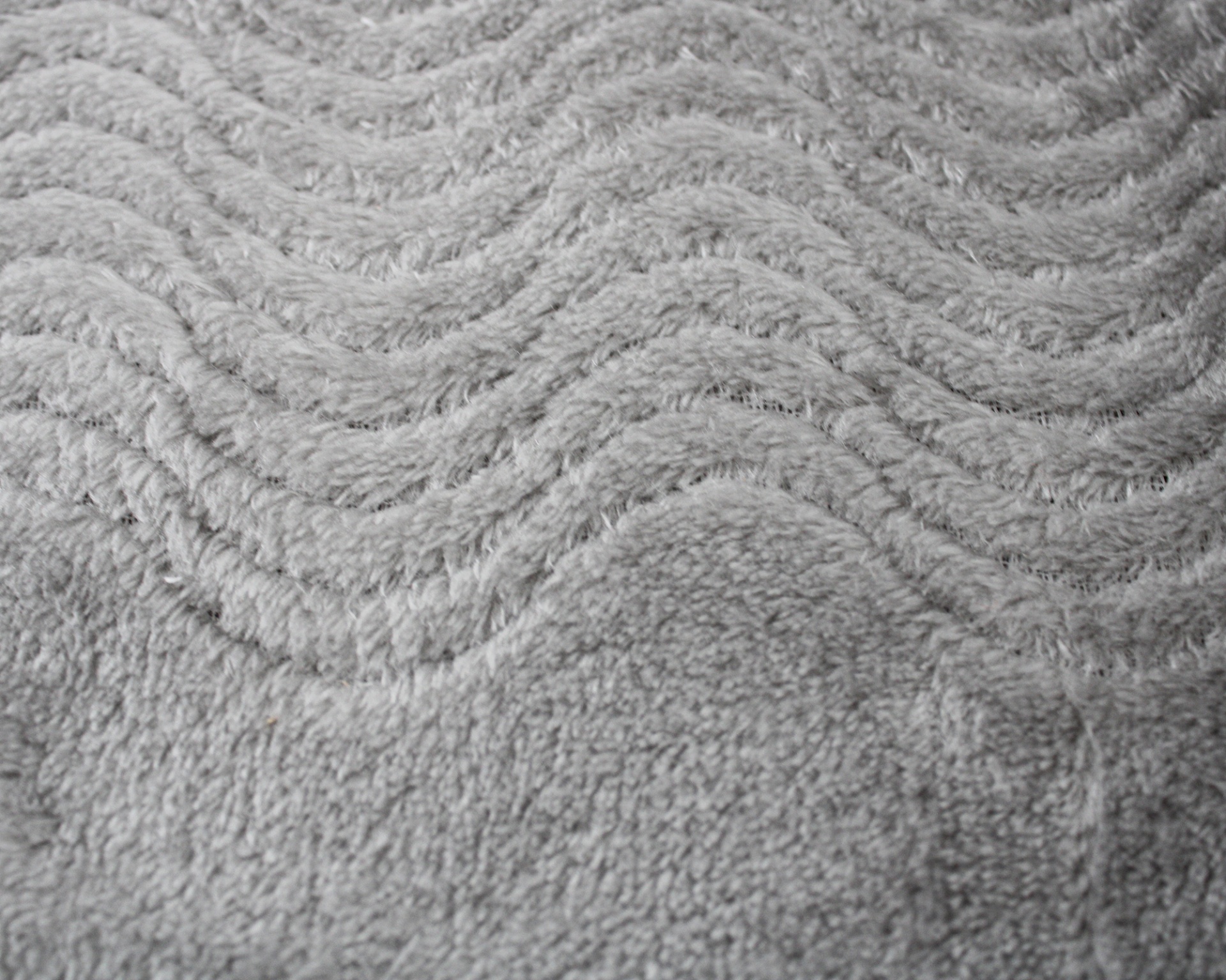 Tecido cinzento texturizado com padrão ondulado em relevo