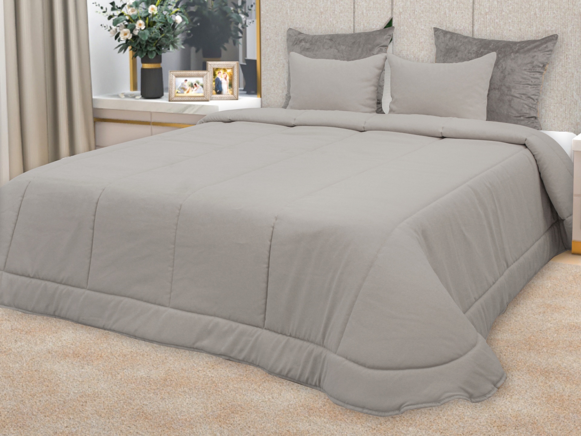 Edredão cinzento liso com padrão de costuras quadradas numa cama de casal