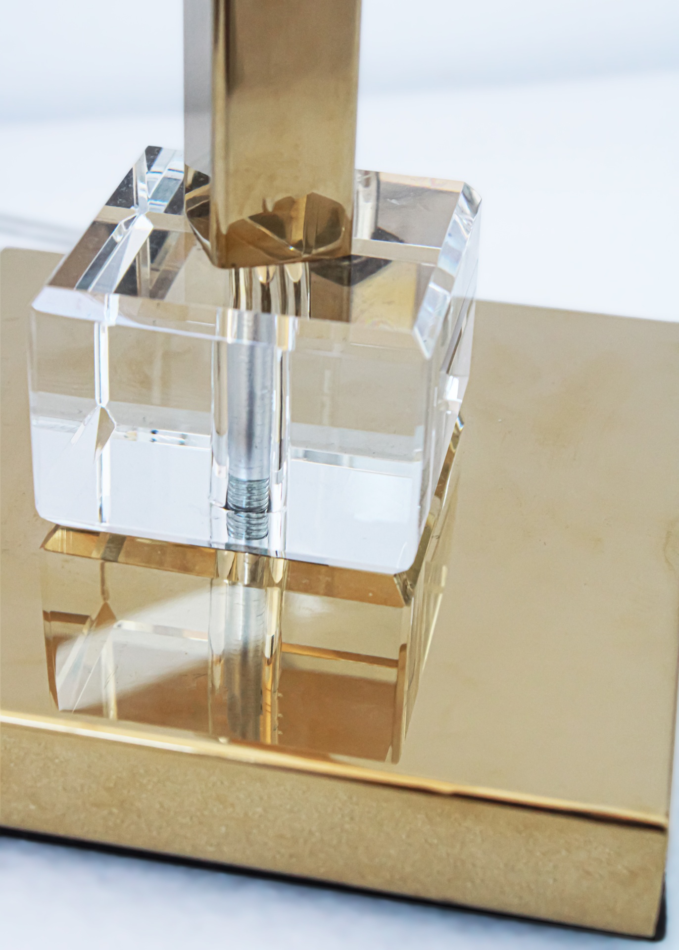 Base de lâmpada dourada com cubo transparente e parafuso visível