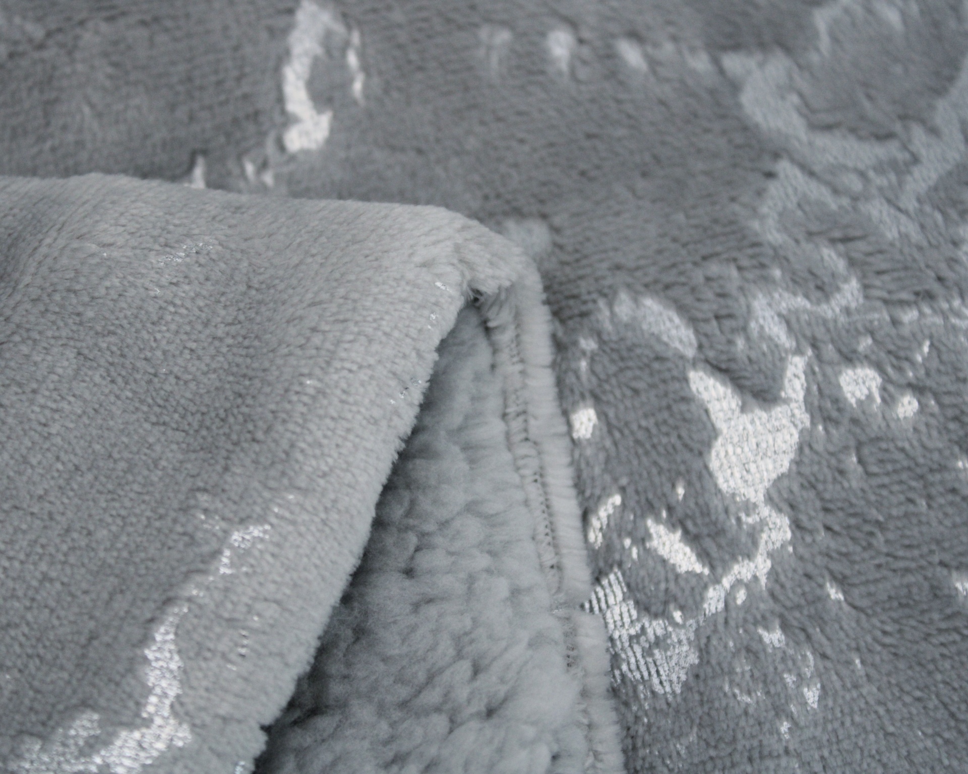 Tecido macio cinzento com padrão floral prateado e interior felpudo