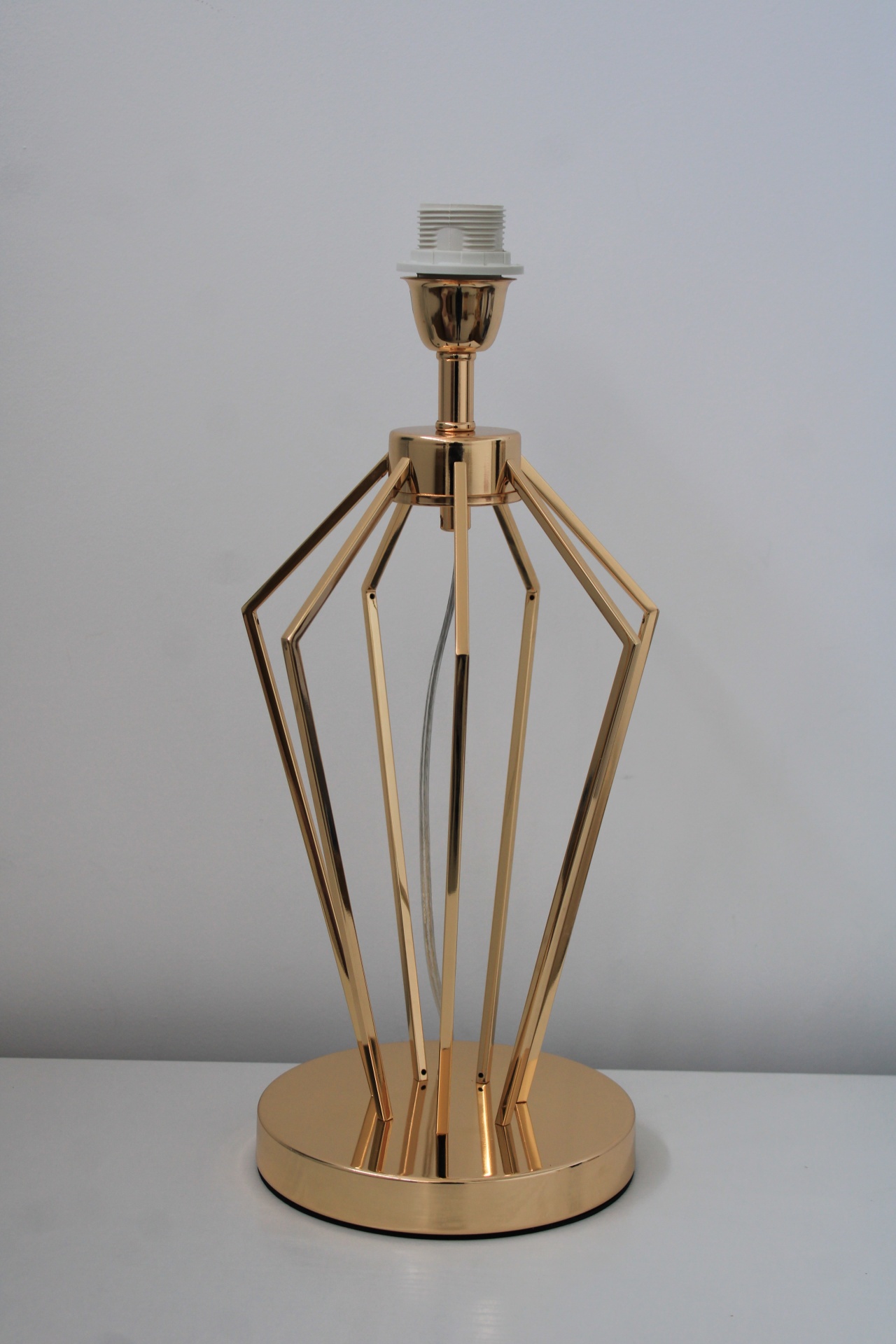 Abajur de mesa dourado em padrão geométrico aberto com base redonda.