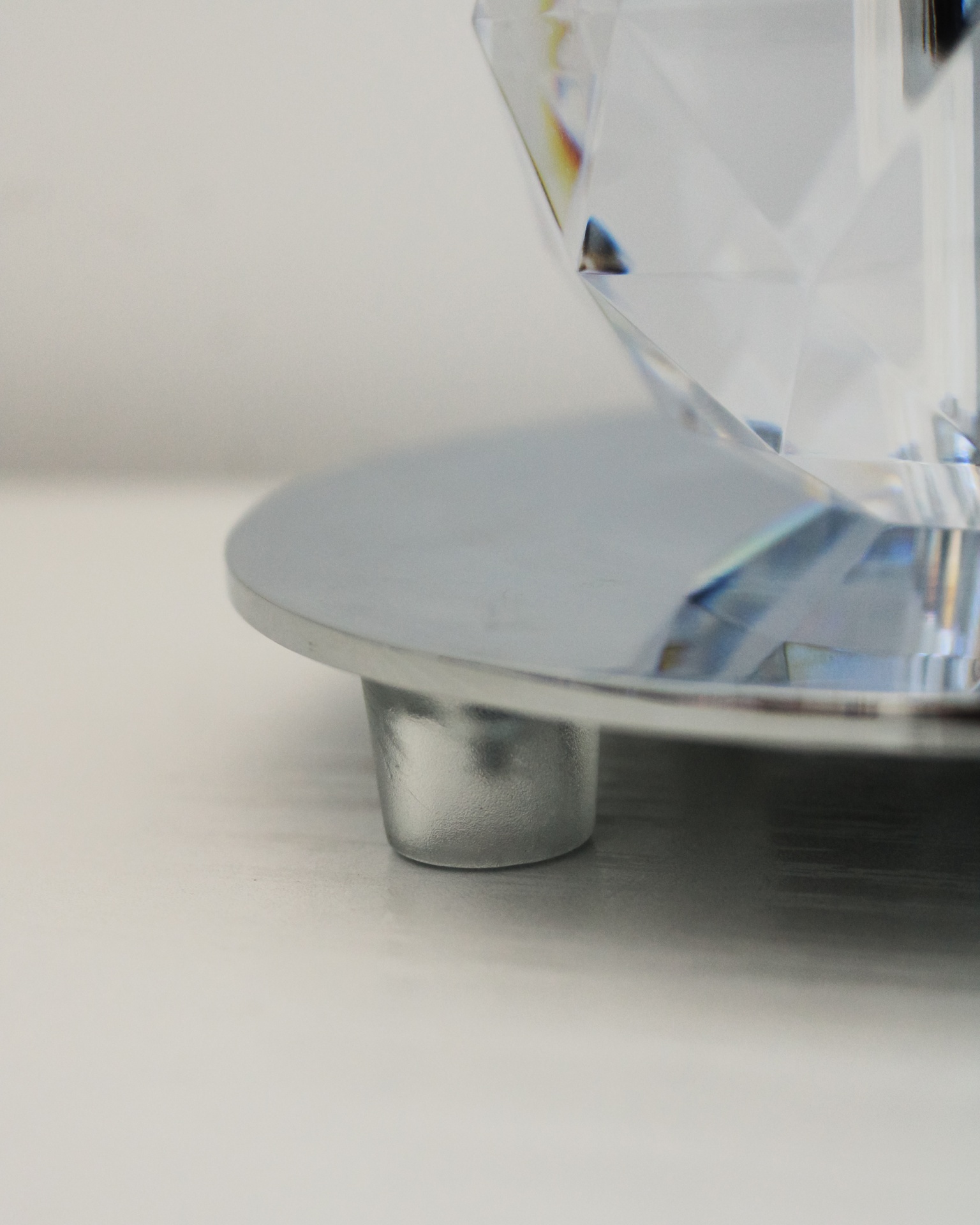 Base metálica prateada com suporte transparente