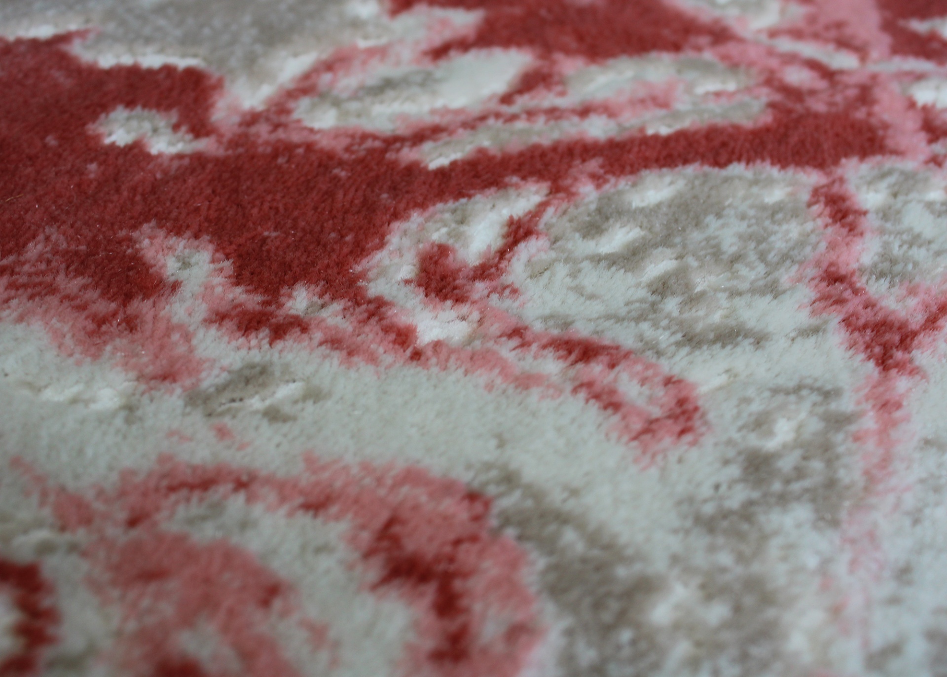 Tapete ou tecido felpudo com padrão abstrato em tons de vermelho, rosa, bege e branco