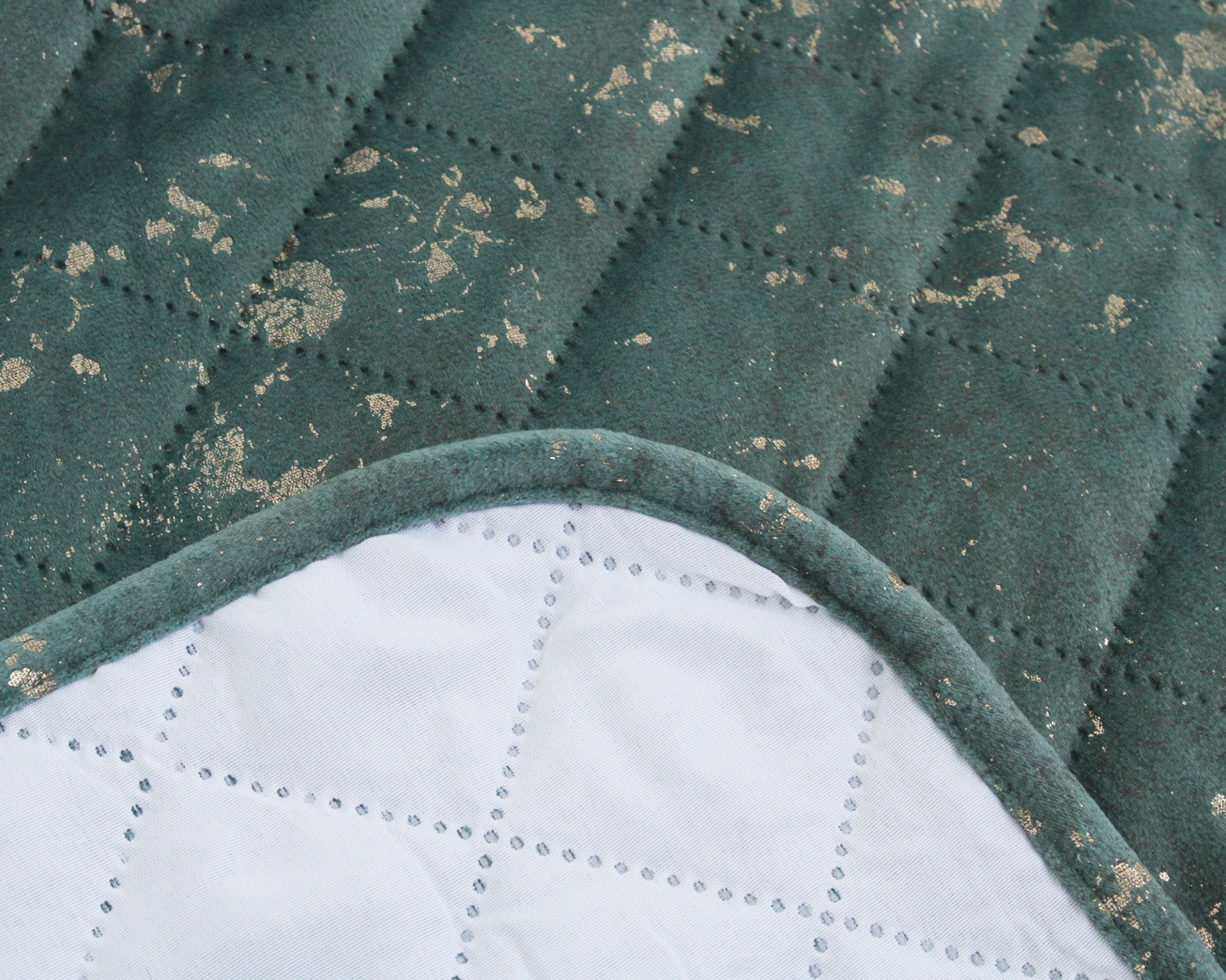 tecido acolchoado verde com manchas douradas e borda arredondada