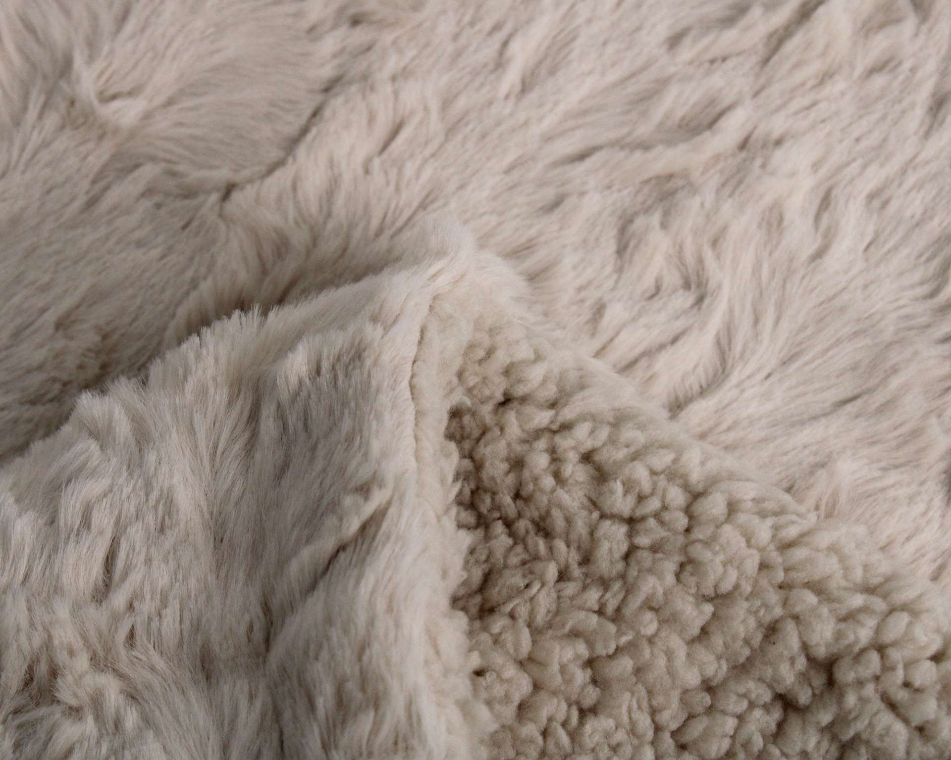 Tecido felpudo creme com texturas diferentes nos dois lados.