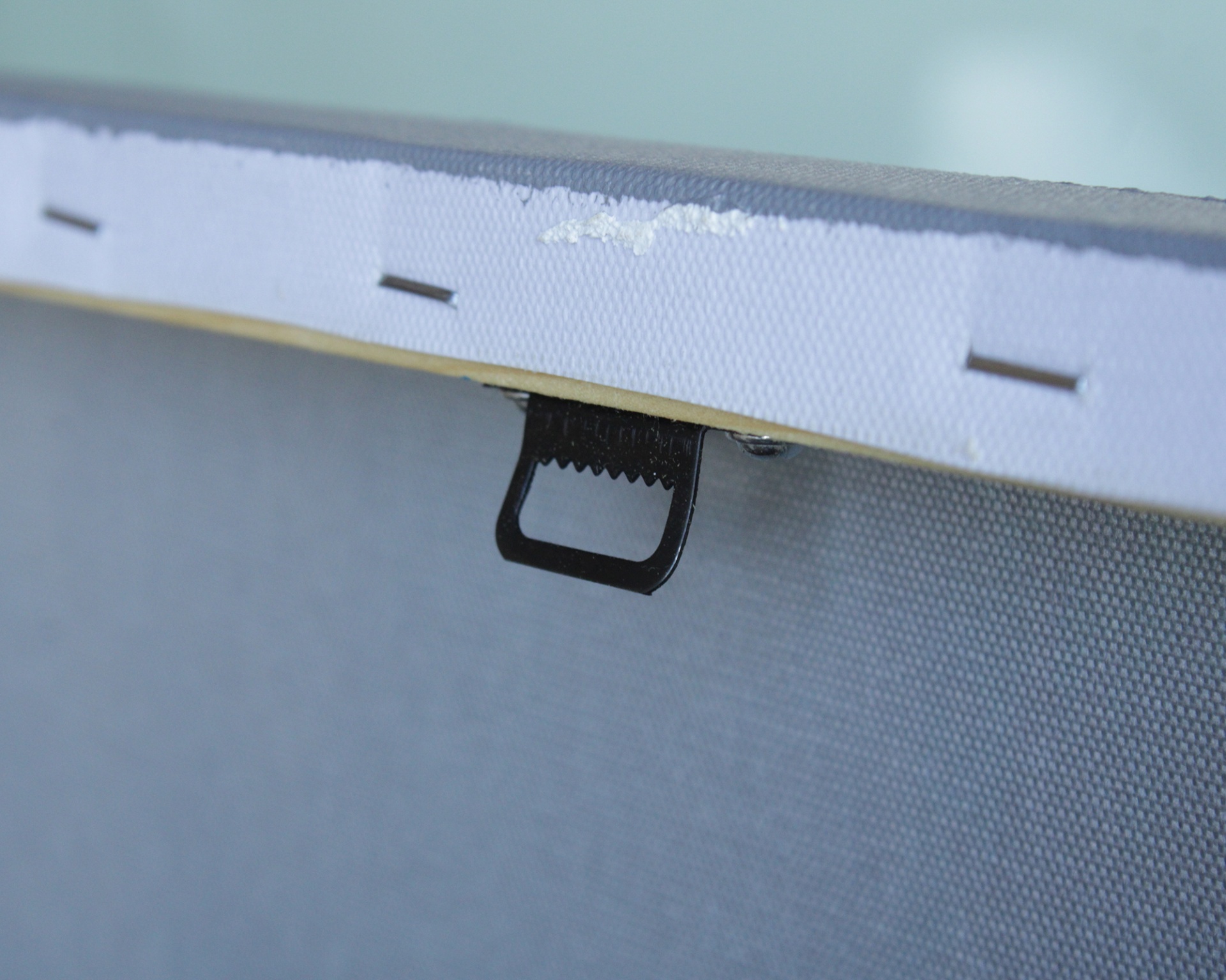 Borda de tela esticada com alça preta e grampos metálicos