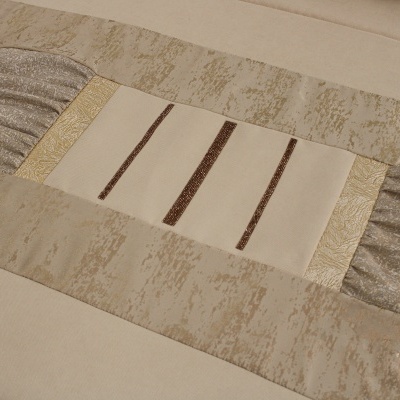 toalha de mesa bege com padrões castanhos e dourados