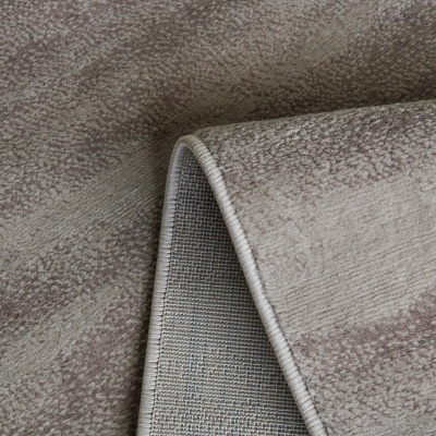 Tapete bege com padrão subtil e dobra mostrando o verso