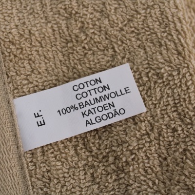 Etiqueta de composição de tecido sobre toalha castanho claro
