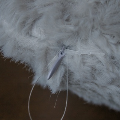 Produto peludo branco com etiqueta plástica