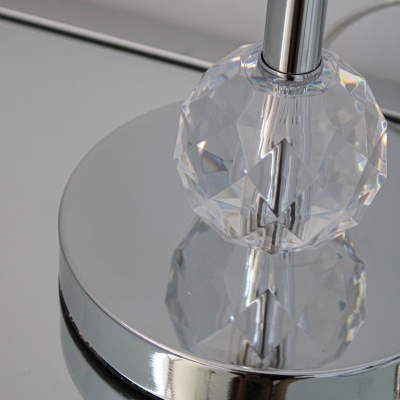 Base metálica espelhada com objeto facetado transparente e suporte cilíndrico prateado