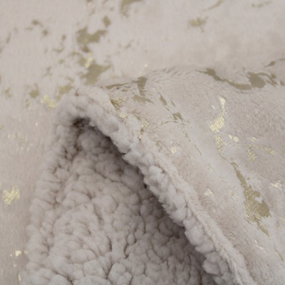 Manta cinzento claro com padrão dourado e textura felpuda