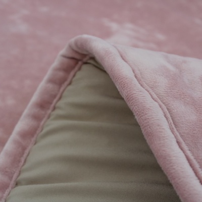 Tapete felpudo rosa com textura aveludada e borda almofadada dobrado