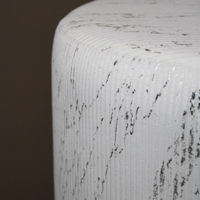 Detalhe de objeto cilíndrico branco com padrão cinzento e textura canelada