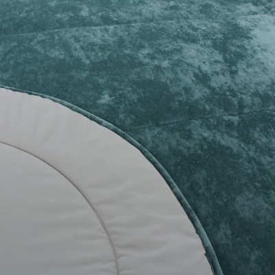 Almofada ou colchão verde-azulado com borda branca e costura visível