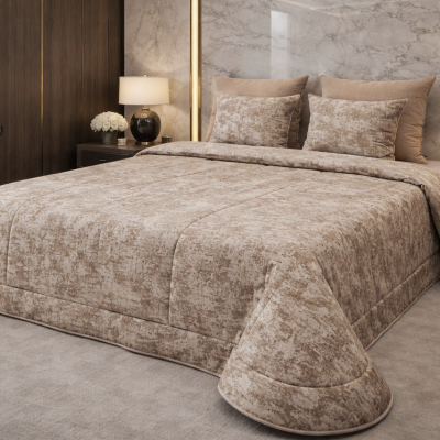 Colcha e almofadas bege com padrão abstracto numa cama king size.