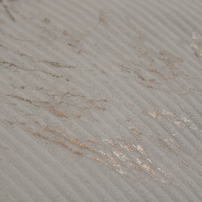 Superfície texturada bege claro com riscas finas e manchas douradas.