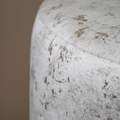 Cilindro branco com manchas cinzentas em fundo bege desfocado