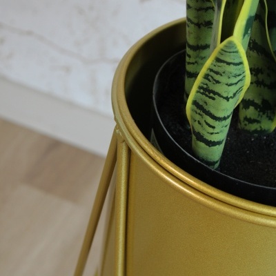Vaso dourado com planta artificial verde e amarela em suporte metálico