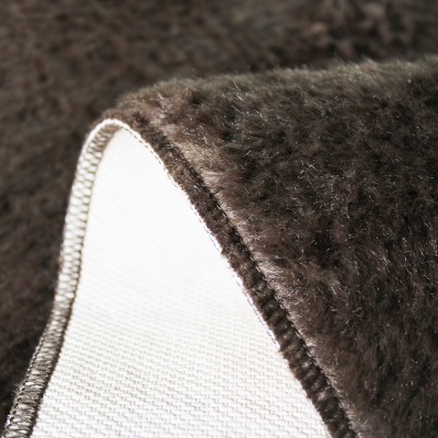 Tapete felpudo castanho escuro com acabamento em costura branca