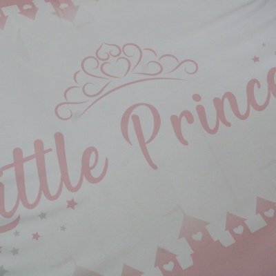 Tecido com design infantil rosa e branco com texto 'Little Princess' e castelos.
