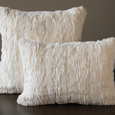 Duas almofadas felpudas brancas em fundo neutro