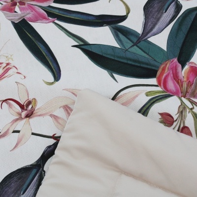 Tecido com padrão floral colorido e almofada creme em tecido liso.