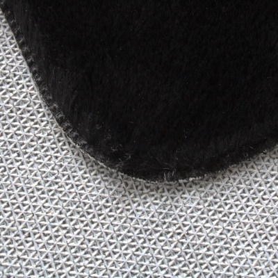 Tapete branco com padrão triangular e tecido preto sobreposto.