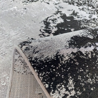 Tapete têxtil preto, cinzento e branco com padrão abstrato e base antiderrapante