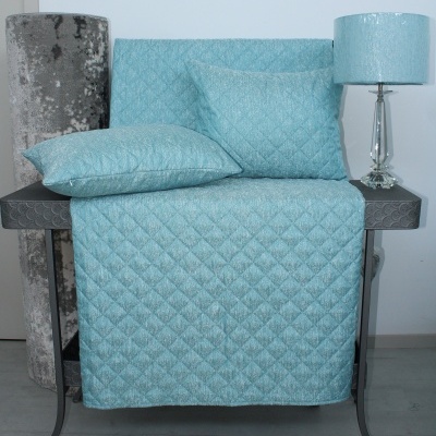 Jogo de cama azul claro acolchoado com almofadas e abajur