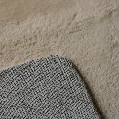 Tapete cinza em textura de malha sobre tecido peludo bege