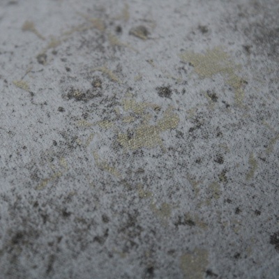 Superfície cinza texturizada com manchas pretas e douradas