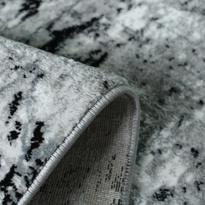 Tapete cinza com padrão abstrato e bordas costuradas