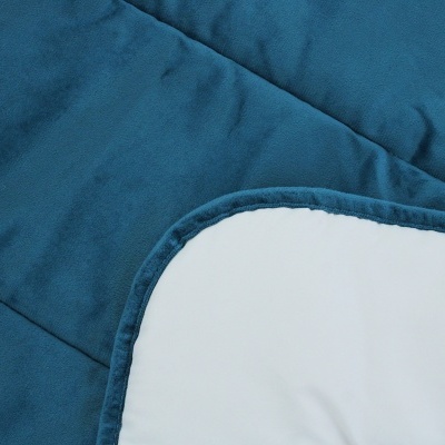 Colcha acolchoada azul com lado branco e bordas arredondadas