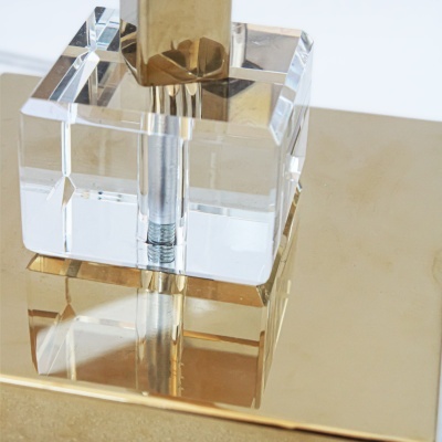 Base de lâmpada dourada com cubo transparente e parafuso visível