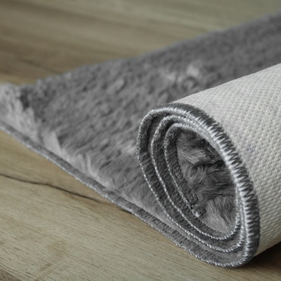 Tapete cinzento felpudo com verso branco e costura cinzenta