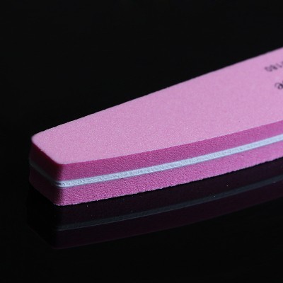 Lima para unhas cor-de-rosa em superfície preta refletora