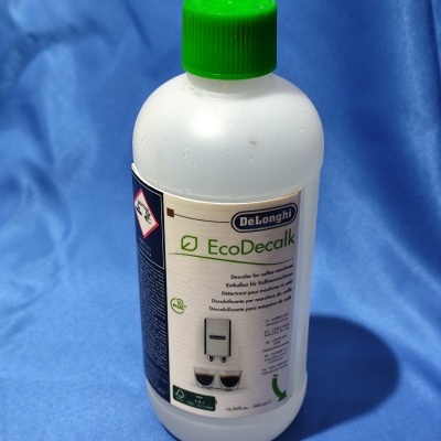 Frasco branco DeLonghi EcoDecalk com tampa verde sobre tecido azul