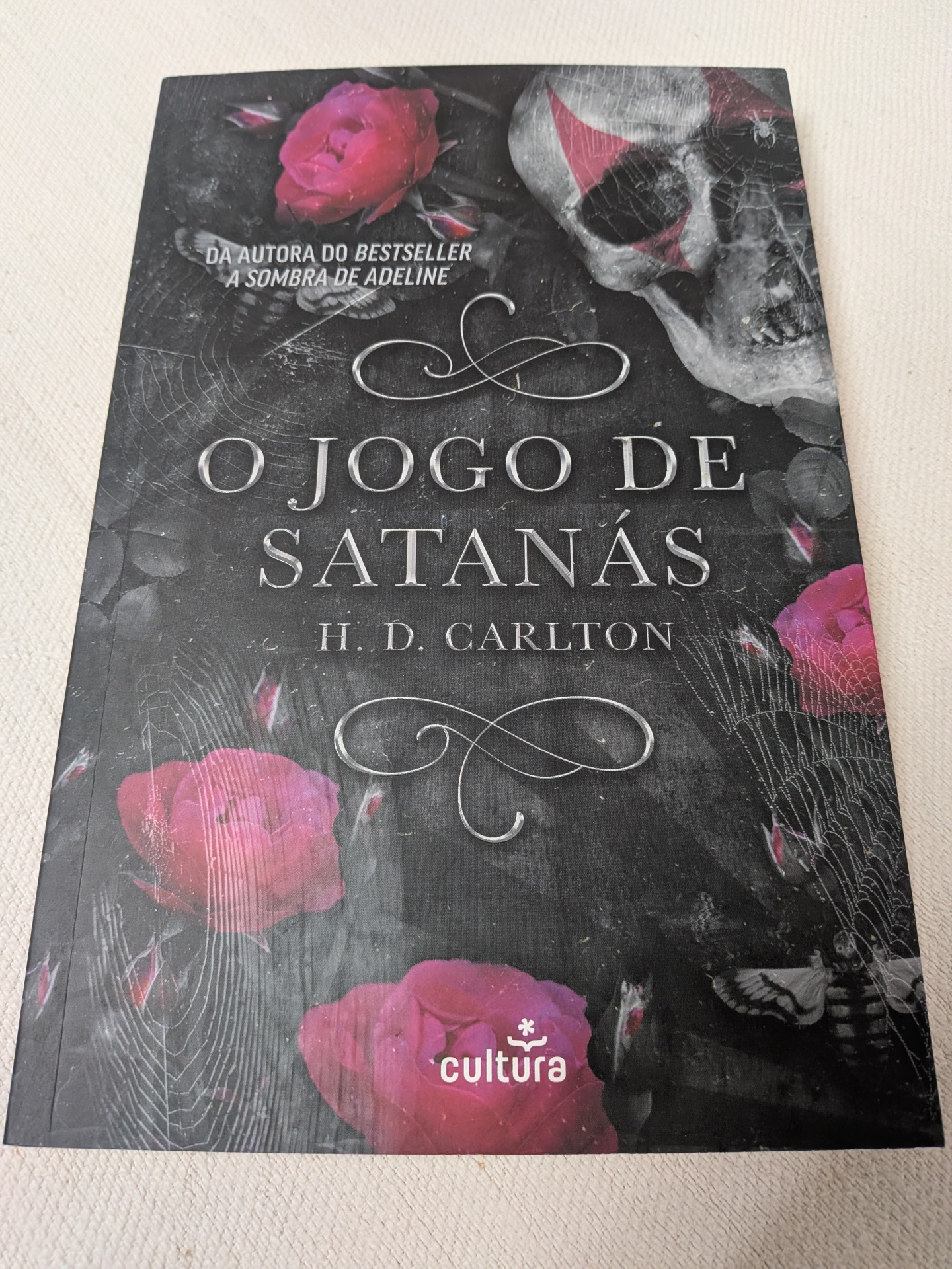 H. D. Carlton - O Jogo de Satanás Capa do livro O Jogo de Satanás com caveira, rosas e teias de aranha