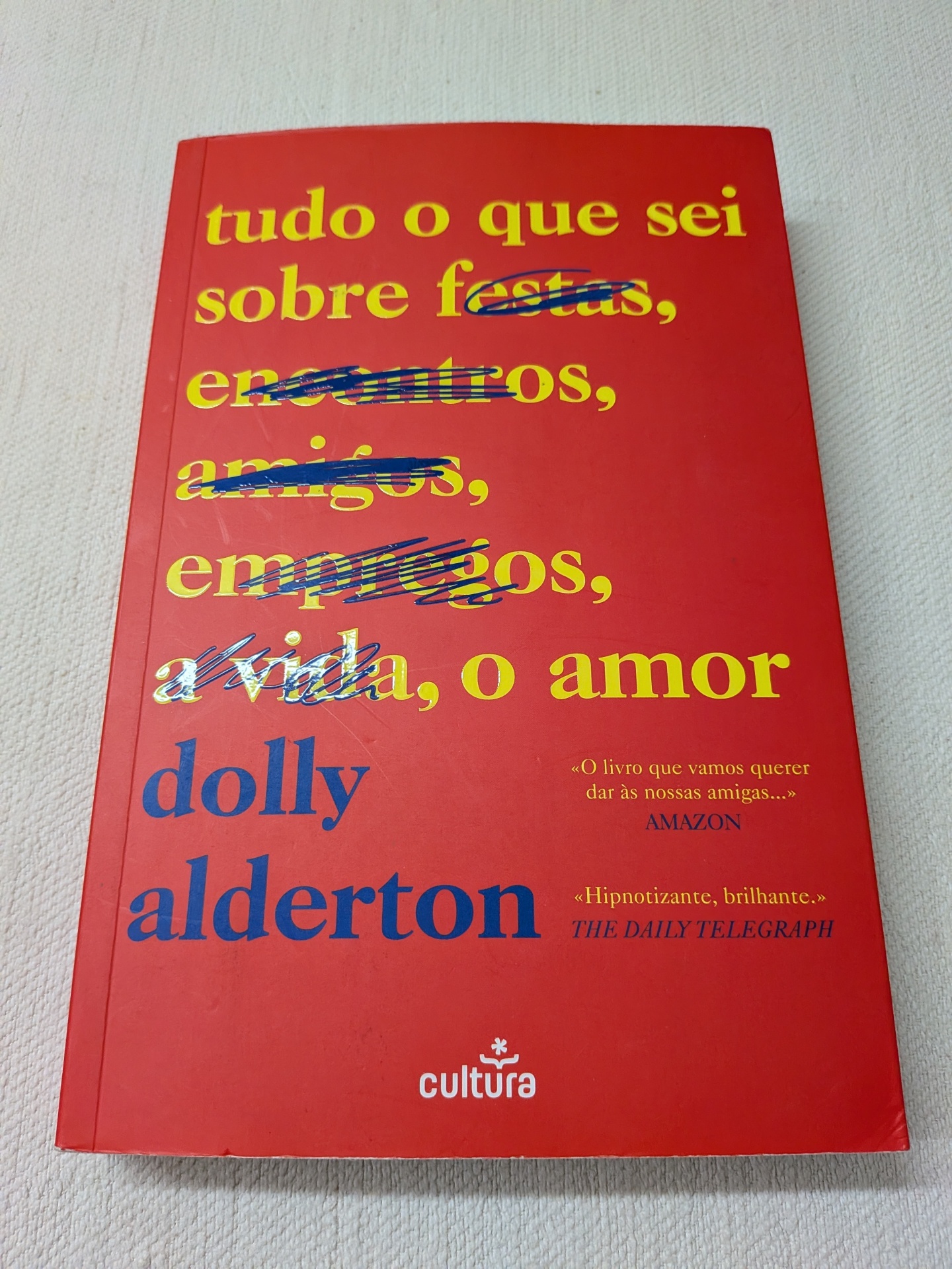Dolly Alderton - Tudo o que Sei Sobre o Amor Livro vermelho com texto amarelo e azul e fundo branco texturizado