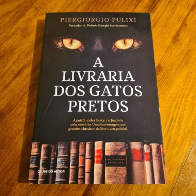 Capa de livro preto com olhos de gato amarelos e livros antigos na base