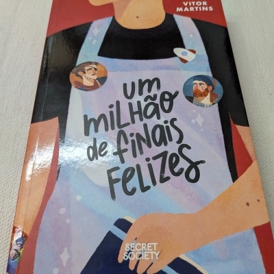 Capa de livro colorida com texto em português e ilustração de uma pessoa com avental