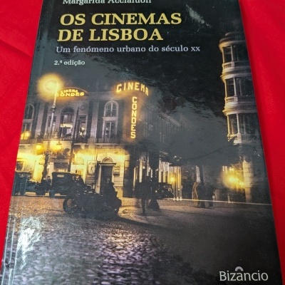 Capa de livro Os Cinemas de Lisboa com foto noturna de cinema antigo e fundo vermelho