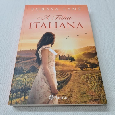 Capa do livro 'A Filha Italiana' com mulher e campo à pôr do sol